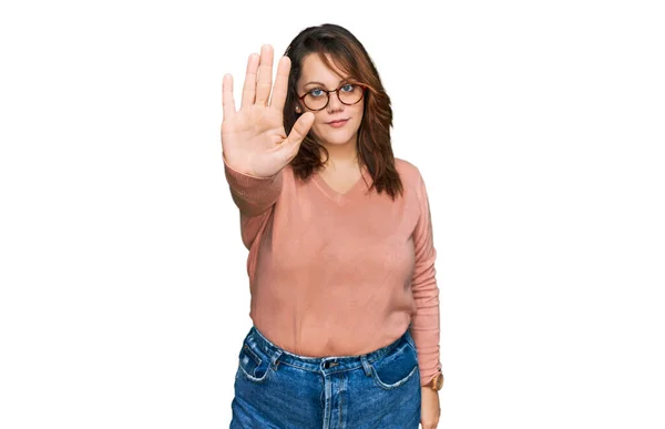 年轻又大的女人 穿着休闲装 戴着眼镜 用手拍着手停止歌唱 用消极而严肃的手势警告人 — 图库照片