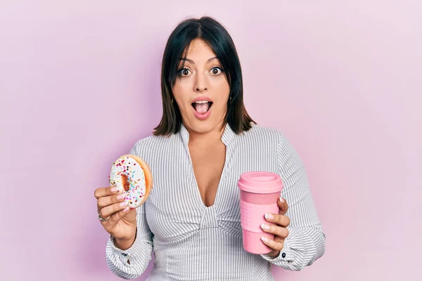 Jovem Hispânica Comendo Donut Bebendo Café Rosto Choque Parecendo Cético — Fotografia de Stock