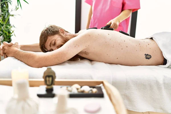 Ung Rödhårig Man Med Ryggmassage Med Svarta Stenar Skönhetscentret — Stockfoto