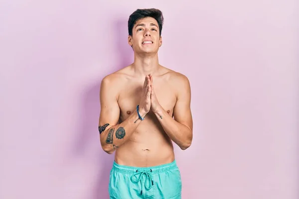 Joven Hombre Hispano Usando Traje Baño Sin Camisa Mendigando Rezando — Foto de Stock