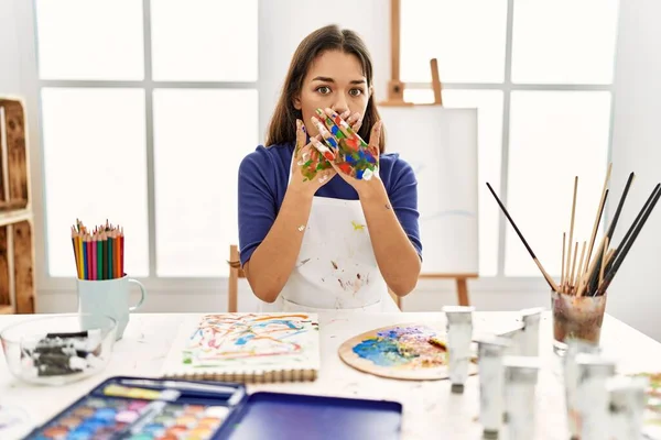 Young Brunette Woman Art Studio Painted Hands Shocked Covering Mouth — Stock Photo, Image