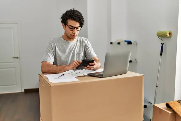 Jovem Hispânico Calcula Economia Usando Laptop Nova Casa — Fotografia de Stock