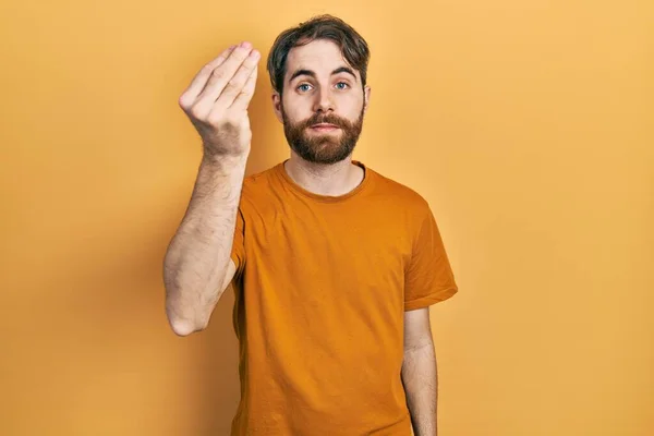 髭を生やした白人男性カジュアルな黄色のTシャツを身に着けていますイタリアのジェスチャーと指で自信を持って式 — ストック写真