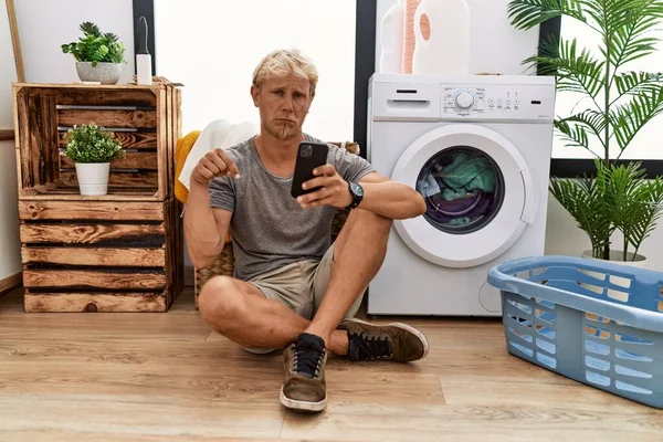 Ung Blond Man Som Tvättar Med Smartphone Pekar Ner Ser — Stockfoto