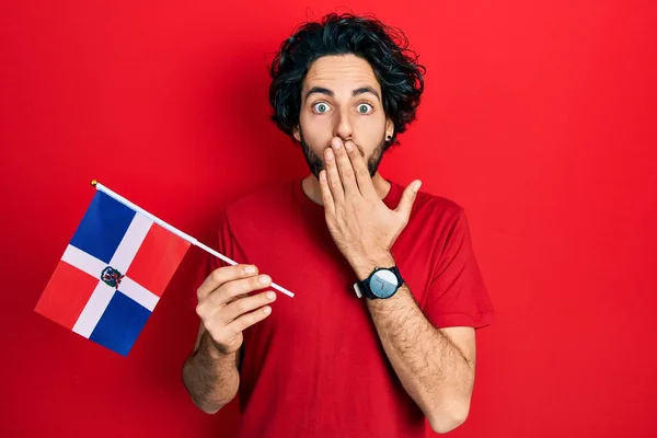 Pohledný Hispánec Držící Dominikánskou Republikovou Vlajku Ústa Rukou Šokovaný Vystrašený — Stock fotografie