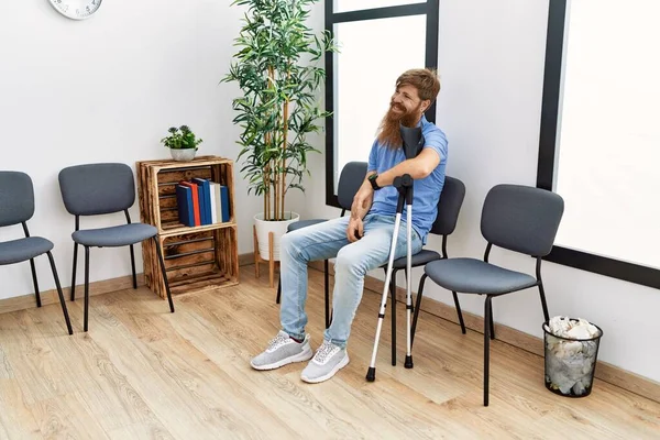 Ung Rödhårig Man Med Kryckor Sittande Stolen Kliniken Väntrum — Stockfoto