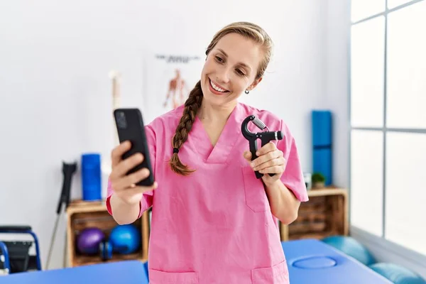 Junge Kaukasische Frau Physiotherapeutenuniform Bei Videotelefonie Mit Handgriff Physiotherapie Klinik — Stockfoto
