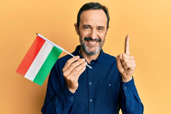 Hispánec Středního Věku Držící Maďarskou Vlajku Usmívající Myšlenkou Nebo Otázkou — Stock fotografie