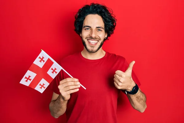 Bello Ispanico Uomo Che Tiene Bandiera Georgia Sorridente Felice Positivo — Foto Stock