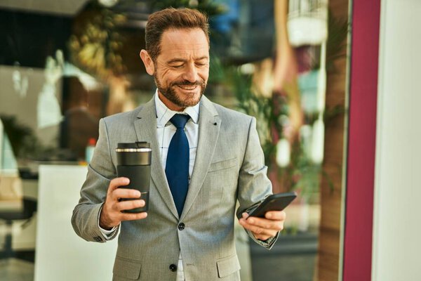 Middle Age Businessman Using Smartphone Drinking Coffee City Stock Photo