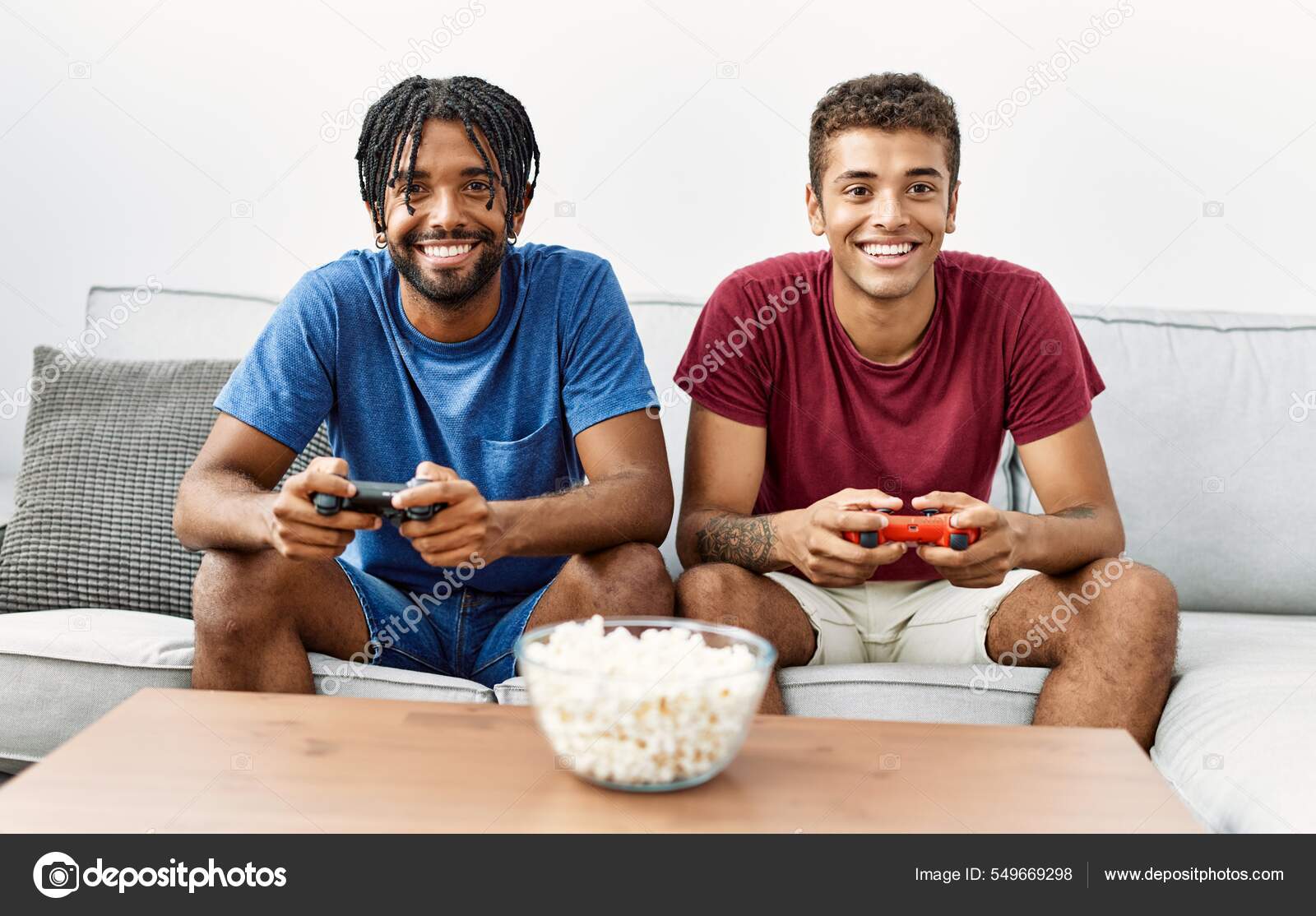 Amigos gamers animados jogando videogame em casa rindo enquanto