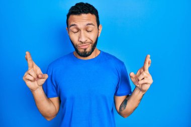 Sakallı, sıradan mavi tişörtlü İspanyol bir adam umut ve gözleriyle gülümseyerek işaret ediyor. Şans ve batıl inançlar. 