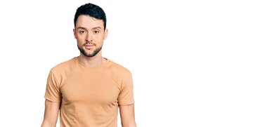 Sakallı, sıradan tişörtlü İspanyol bir adam. Yüzünde ciddi bir ifadeyle rahatlamış. Basit ve doğal bir şekilde kameraya bakıyorsun.. 