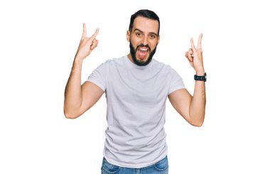 Sakallı, beyaz tişörtlü, çılgın bir ifadeyle bağıran, elleri havada rock sembolü yapan genç bir adam. Müzik yıldızı. ağır müzik konsepti. 