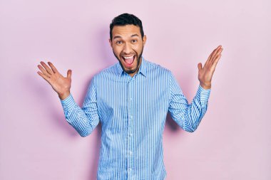 Mavi gömlekli İspanyol bir adam çılgın kutlamalar yapıyor ve kolları açık ve gözleri açık heyecanla haykırıyor. Kazanan konsept 