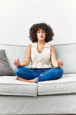 Ortadoğulu genç kadın evde yoga egzersizi yapıyor.