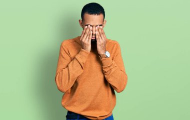 Genç Afro-Amerikan adam günlük kıyafetler giyiyor yorgunluk ve baş ağrısı için gözlerini ovuşturuyor, uykulu ve yorgun bir ifade takınıyor. görme sorunu 