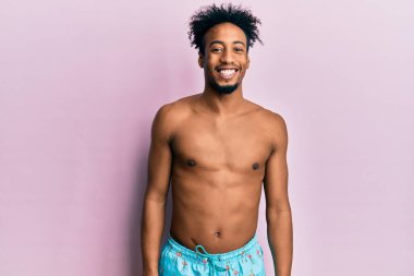 Yüzünde mutlu ve havalı bir gülümseme olan sakallı, Afro-Amerikalı genç bir adam. şanslı kişi. 