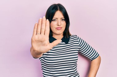 Günlük kıyafetler giyen genç İspanyol kadın avucunun içi gibi şarkı söylemeyi kesiyor. Yüzünde olumsuz ve ciddi bir jest olan uyarı ifadesi. 
