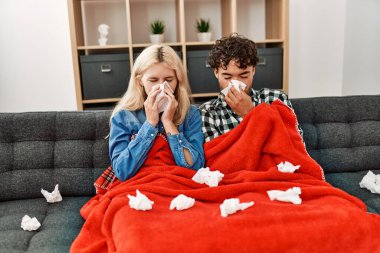 Genç hasta çift evdeki kanepede peçete kullanıyor..