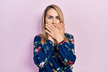 Günlük giysiler giyen genç beyaz kadın yanlışlıkla elleri ile ağzını kapatırken şok oldu. gizli kavram. 