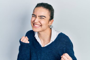 Başarı için heyecanlı, kolları havada, gözleri kapalı, sıradan kıyafetler giyen genç beyaz kız zaferi kutluyor. Kazanan konsept. 