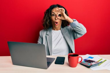 Ofiste çalışan orta yaşlı güzel bir kadın. Bir fincan kahve içiyor. Şok olmuş bir jest yapıyor. İnançsız ifade. 