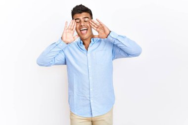 Soyutlanmış arka planda dikilen iş gömleği giyen genç İspanyol adam gülümseyerek yüzünü göstererek bön bön bakıyor. Şaşırdım ve çıktım. 