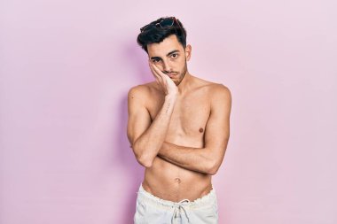 Mayo giyen genç İspanyol adam kollarını kavuşturarak depresyondan sıkılmış ve yorgun görünüyor.. 