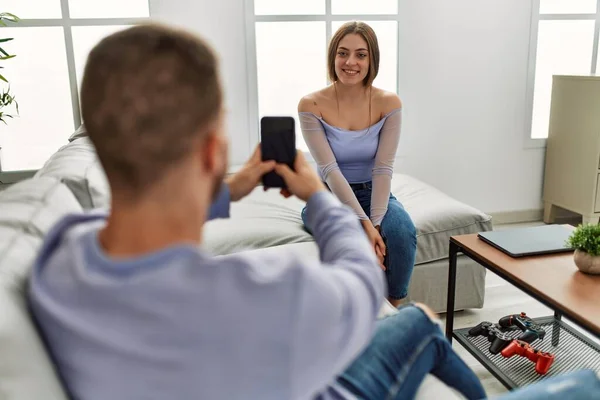 年轻男子在家里用智能手机给女朋友拍照 — 图库照片