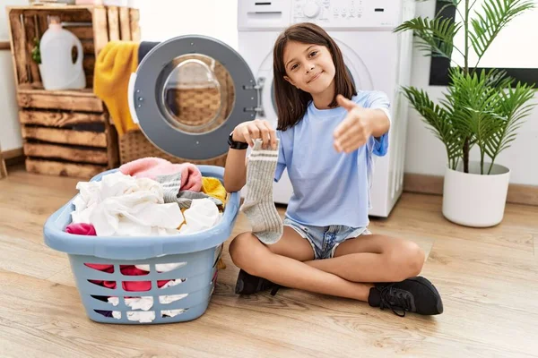 Ung Latinamerikansk Flicka Gör Tvätt Hålla Strumpor Ler Vänlig Erbjuder — Stockfoto