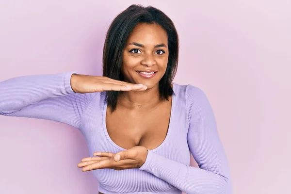 年轻的非洲裔美国女孩 身穿休闲装 手拿着大号和大号的手势 测量符号 微笑着看着摄像机 计量概念 — 图库照片
