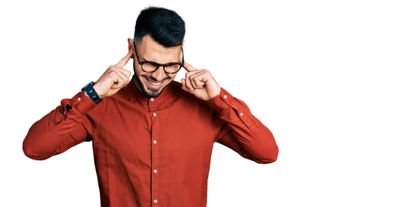 年轻的男人 留着胡子 穿着商务衬衫 戴着眼镜 用手指捂住耳朵 对嘈杂的音乐感到恼怒 聋人概念 — 图库照片