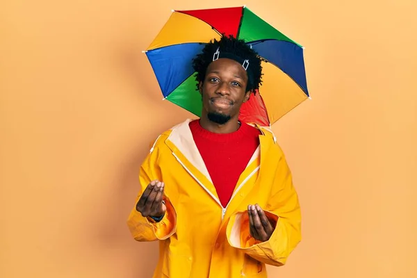 Young African American Man Wearing Yellow Raincoat Doing Money Gesture — Fotografia de Stock
