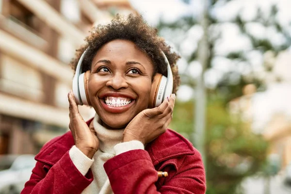 Красивая Африканская Американка Афроволосами Улыбающаяся Счастливая Уверенная Себе Наушниках Слушающая — стоковое фото