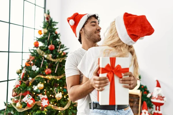 Genç Çift Noel Şapkası Takıyor Evde Sarılıyor Hediyelerini Tutuyorlar — Stok fotoğraf