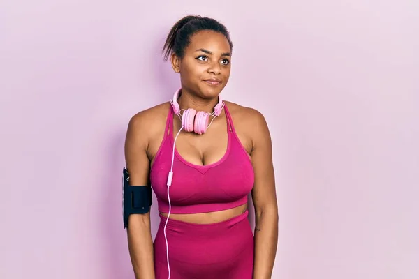 Joven Afroamericana Chica Usando Ropa Gimnasio Uso Auriculares Sonriendo Mirando —  Fotos de Stock