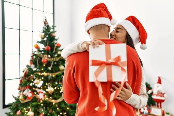 Młoda Latynoska Para Uśmiechnięta Szczęśliwa Przytulona Trzymająca Świąteczny Prezent Domu — Zdjęcie stockowe