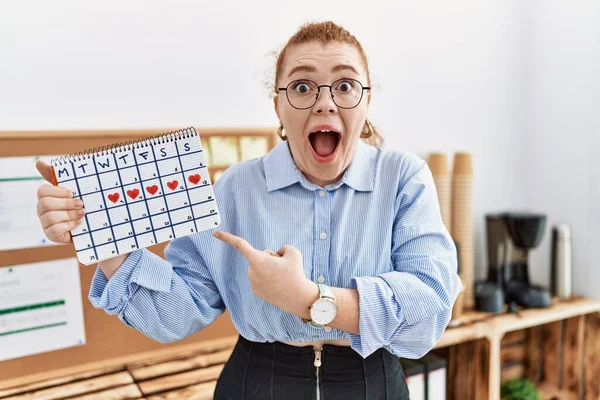 Jonge Roodharige Vrouw Met Hart Kalender Kantoor Glimlachend Gelukkig Wijzend — Stockfoto