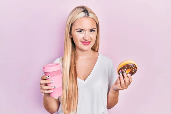 Menina Loira Jovem Comer Donut Beber Café Sem Noção Expressão — Fotografia de Stock