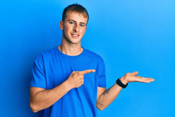 Joven Hombre Caucásico Vistiendo Casual Camiseta Azul Asombrado Sonriendo Cámara — Foto de Stock