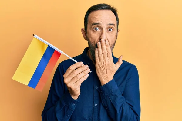 Homem Hispânico Meia Idade Segurando Bandeira Colômbia Cobrindo Boca Com — Fotografia de Stock