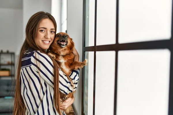 Junge Hispanische Frau Lächelt Selbstbewusst Umarmenden Hund Der Hause Steht — Stockfoto