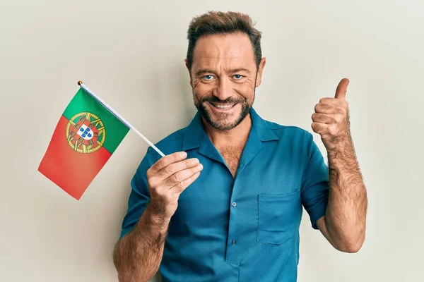 Orta Yaşlı Adam Portekiz Bayrağını Tutuyor Mutlu Pozitif Gülümsüyor Başparmağıyla — Stok fotoğraf