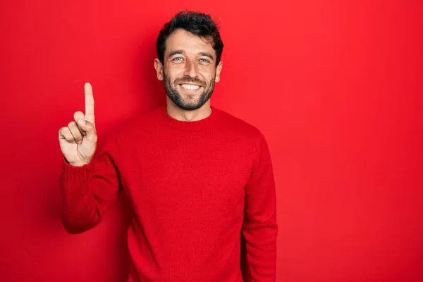 Tampan Pria Dengan Jenggot Mengenakan Sweater Merah Kasual Menunjuk Jari — Stok Foto