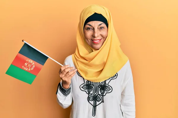 Middle Age Hispanic Woman Holding Afghanistan Flag Looking Positive Happy — Stock Photo, Image