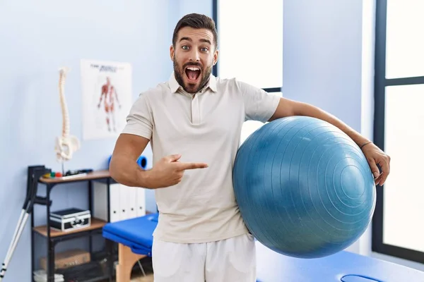 Bonito Homem Hispânico Segurando Bola Pilates Clínica Reabilitação Sorrindo Feliz — Fotografia de Stock