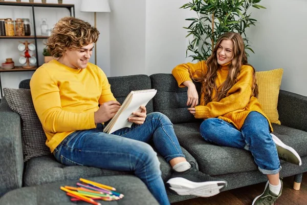 Jong Kaukasisch Paar Glimlachen Zelfverzekerd Tekening Portret Notebook Thuis — Stockfoto