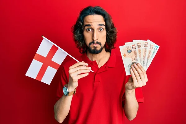 Joven Hispano Sosteniendo Bandera Inglaterra Libras Billetes Soplando Mejillas Con —  Fotos de Stock