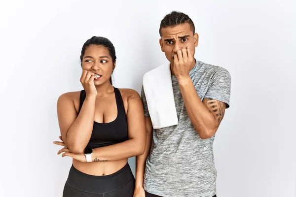 Young Latin Couple Wearing Sportswear Standing Isolated Background Looking Stressed — Stok fotoğraf